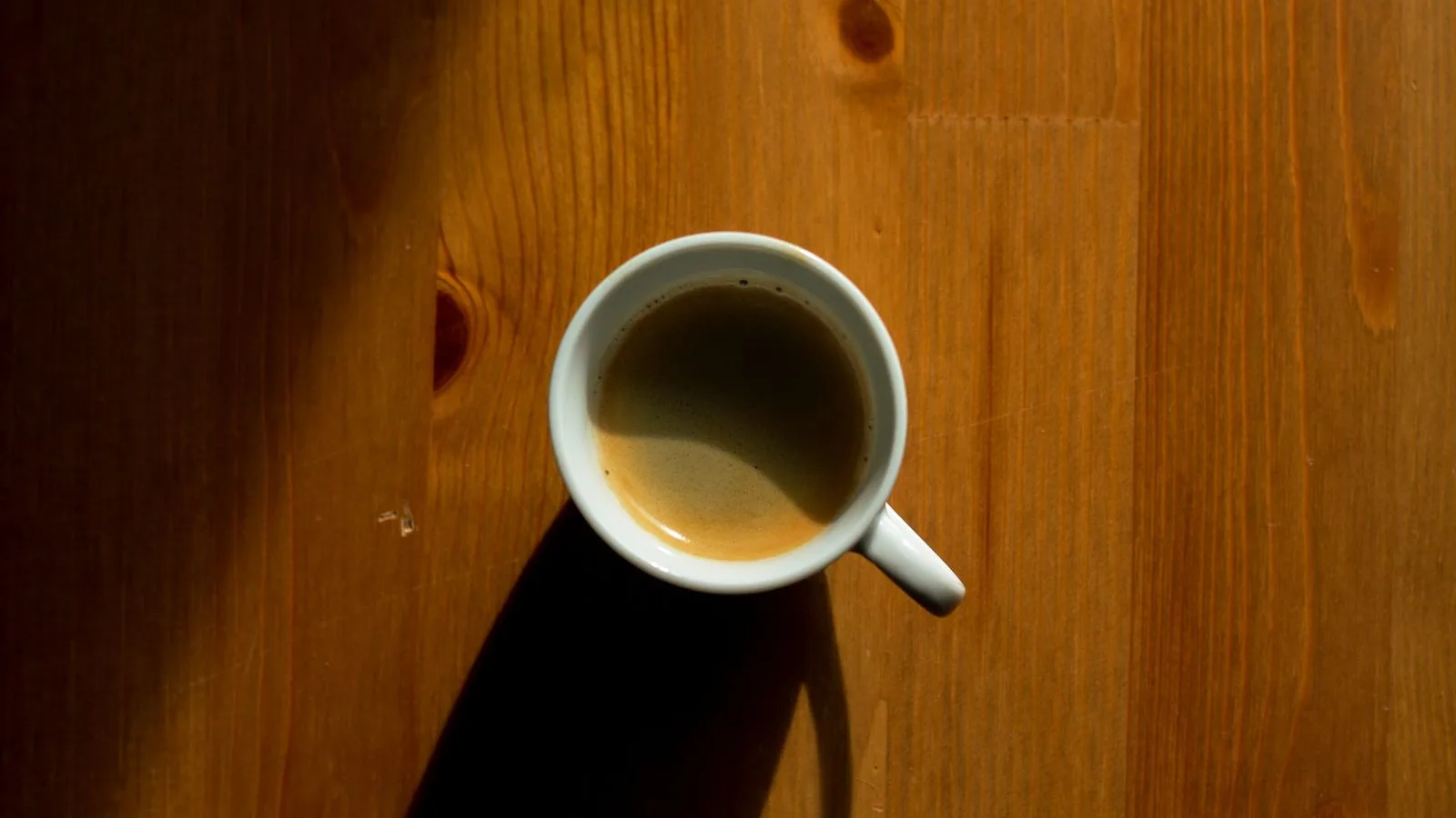 A small cup of coffee on a wooden table