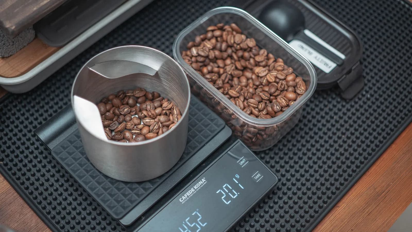 Coffee beans weighed in a dosing cup on a digital scale