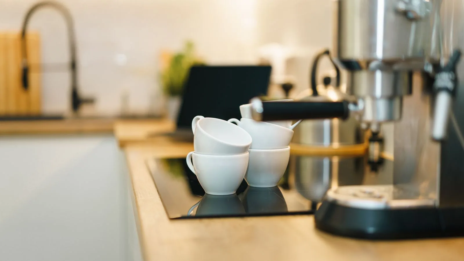 An espresso machine and cups on a kitchen counter
