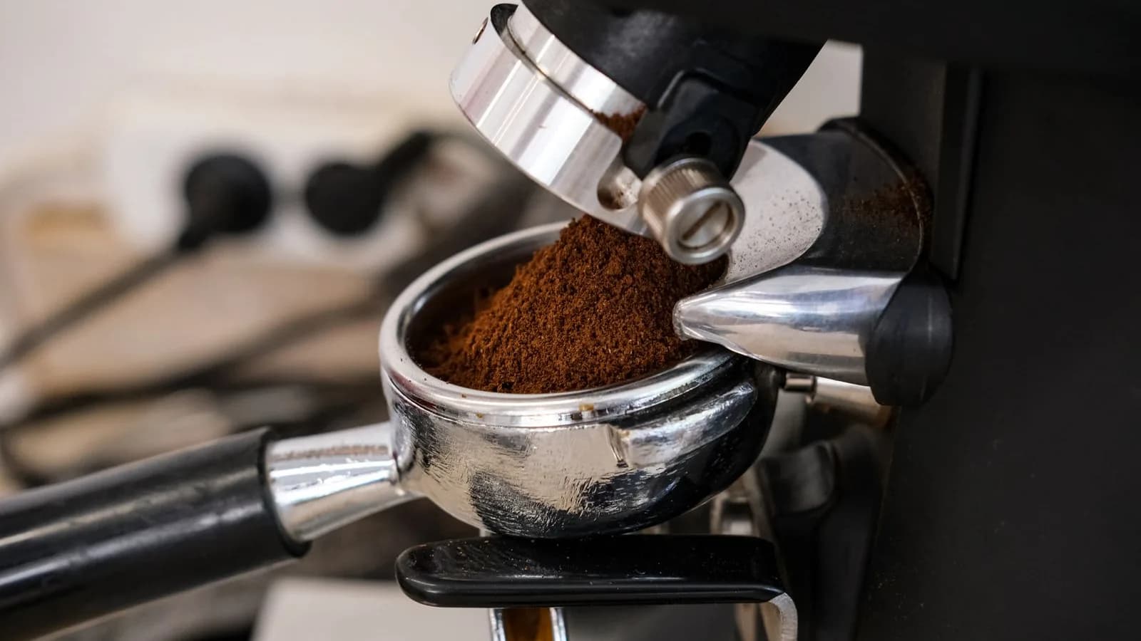 Photo by Esra Afşar on Pexels (Pexels License) Ground coffee falling from a grinder into a metal portafilter