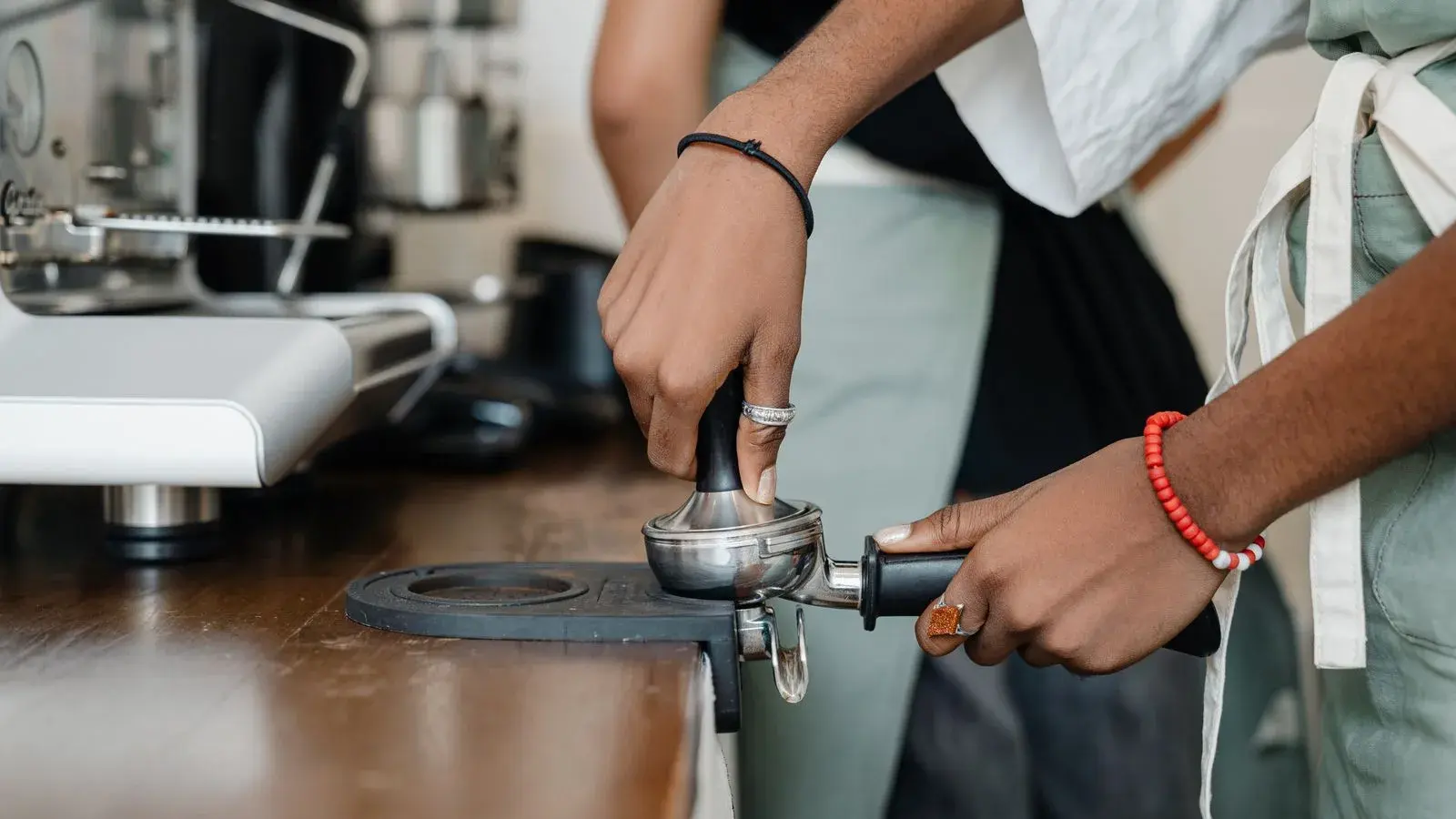 Photo by Ketut Subiyanto on Pexels A barista tamping coffee grounds in a portafilter