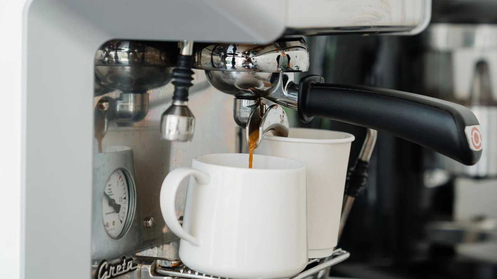 Espresso pouring from a portafilter into cups