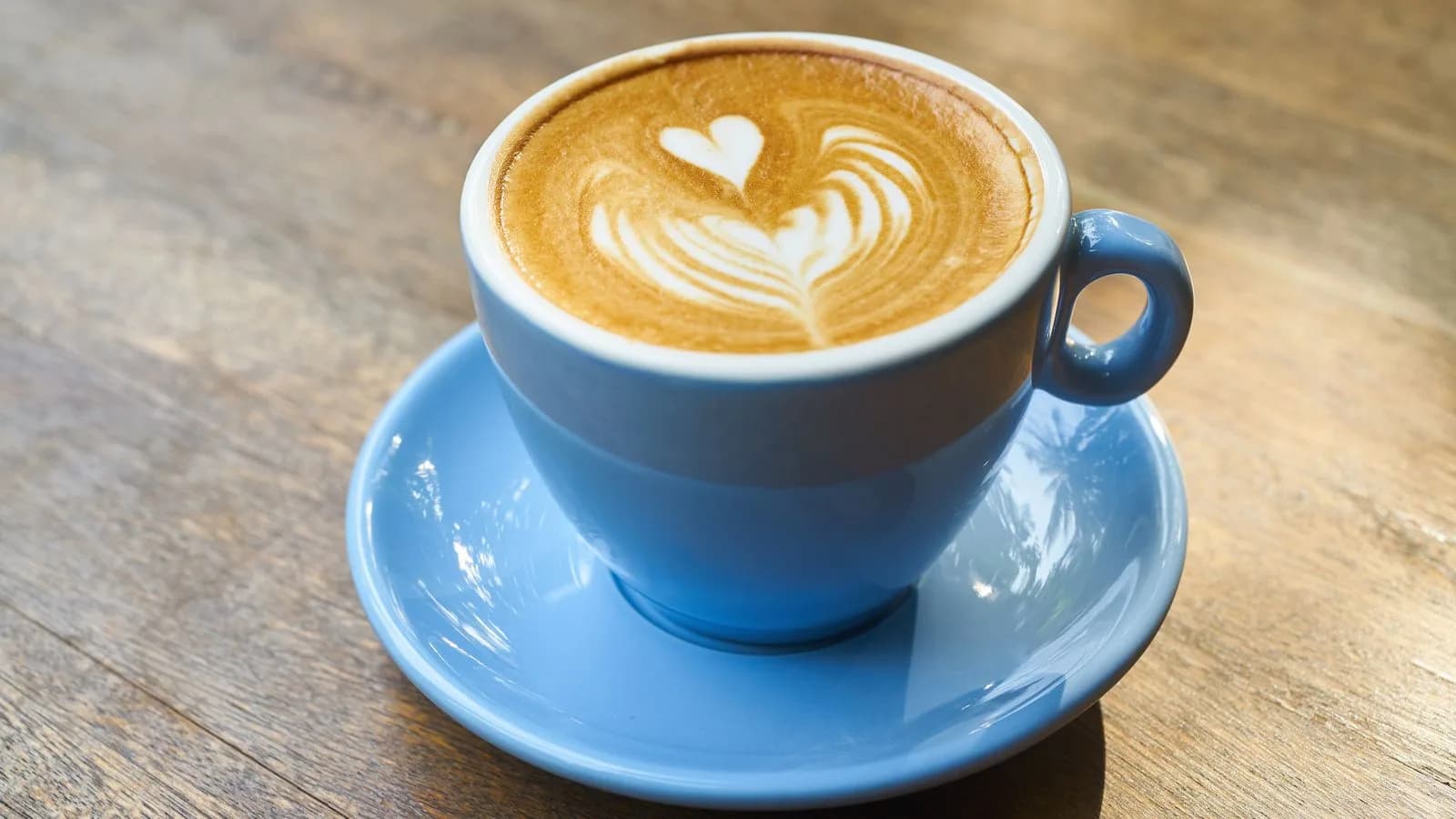 Milk coffee with latte art in a blue cup