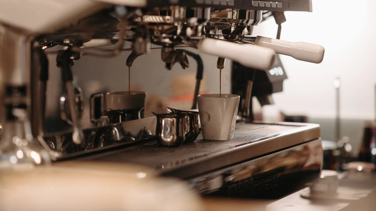 Coffee pouring from an espresso machine into a cup
