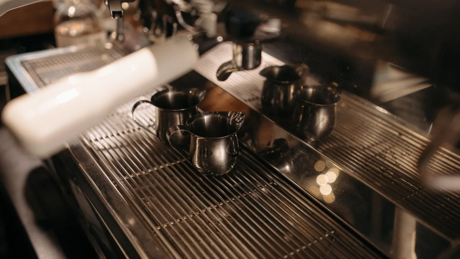 An espresso machine drip tray with milk pitchers